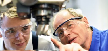 Berufsausbildung im Handwerk: Jugendlicher und Lehrer an einer CNC Maschine Berufsausbildung im Handwerk: Jugendlicher und Lehrer an einer CNC Maschine