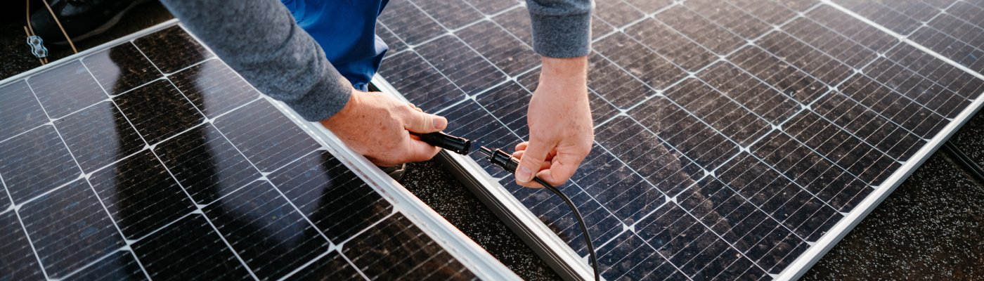 Worker installing solar energy panels. connect two panel together. eco concept