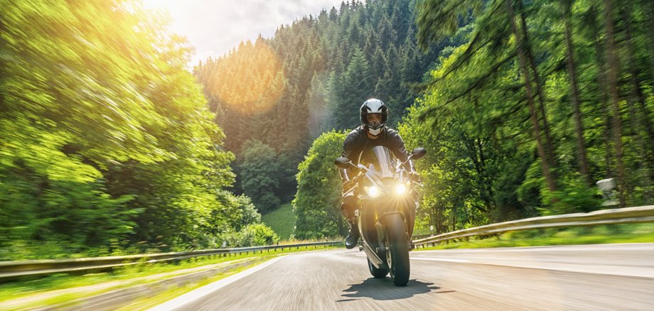 Mit dem Motorrad auf einer Waldstraße unterwegs