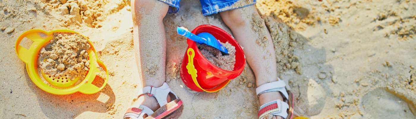 Adorable little girl on playground in sandpit