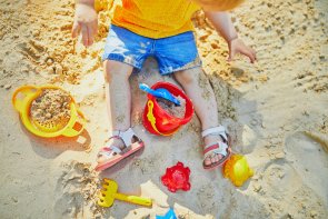 Adorable little girl on playground in sandpit