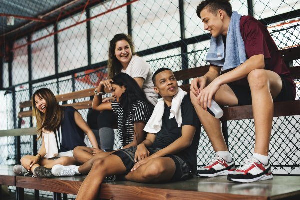 Group of young teenager friends sitting on a bench relaxing Group of young teenager friends sitting on a bench relaxing