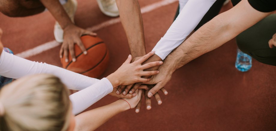 Top view of basketball team holding hands over court