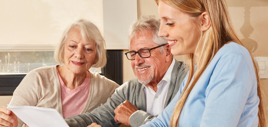 Frau hilft Senioren bei Formularen