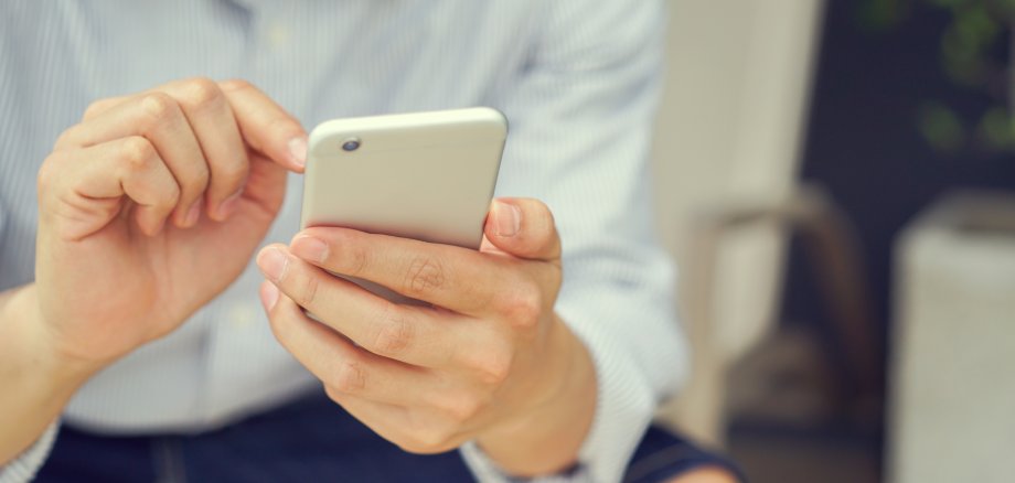 close up hand hold mobile cell phone device:focus on man play on smartphone concept