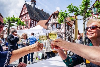 Menschen stoßen mit Wein auf dem Altstadtmarkt an