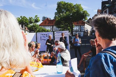 Bürgerinnen und Bürger besprechen auf dem Marktplatz die Ideen aus den Stadtspaziergängen