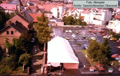 Blick auf den Rathausplatz der noch ein betonierter großer Parkplatz ist.