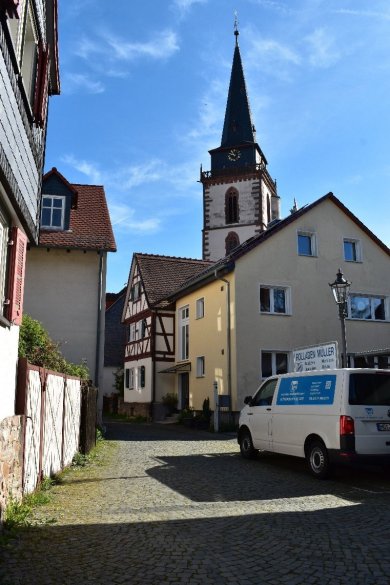 Gleicher Blickwinkel wie das alte Foto. Man sieht den Kirchturm. Alle Gärten davor scheinen verschwunden. Überall stehen Häuser